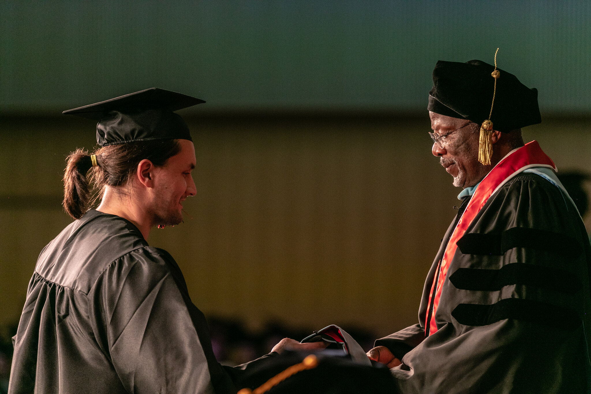 Student shaking hands with his professor at the hooding ceremony
