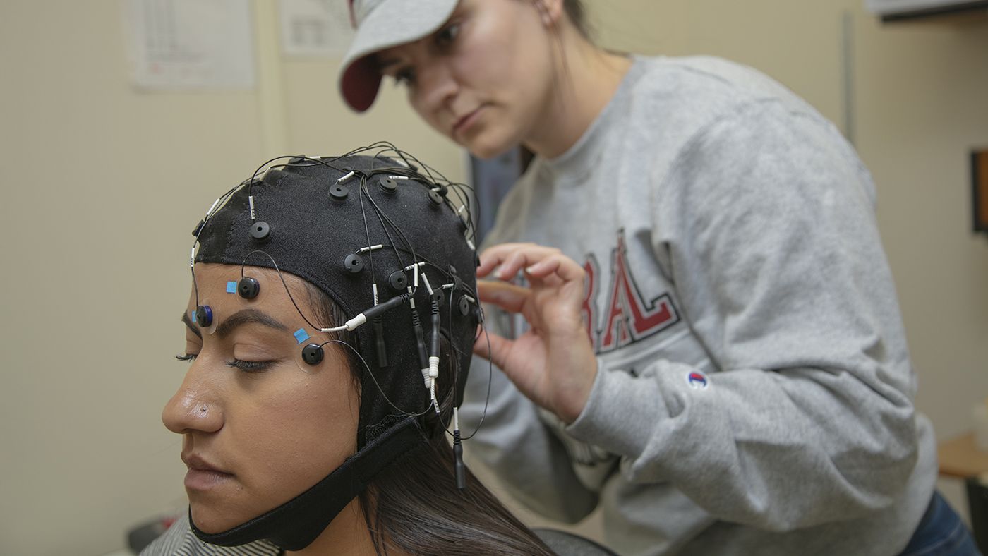 A woman conducts a brain study on another woman at Central Washington University.