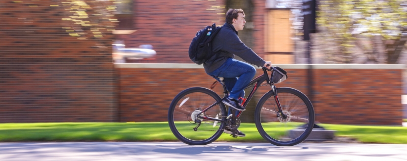 A person riding their bike through campus.