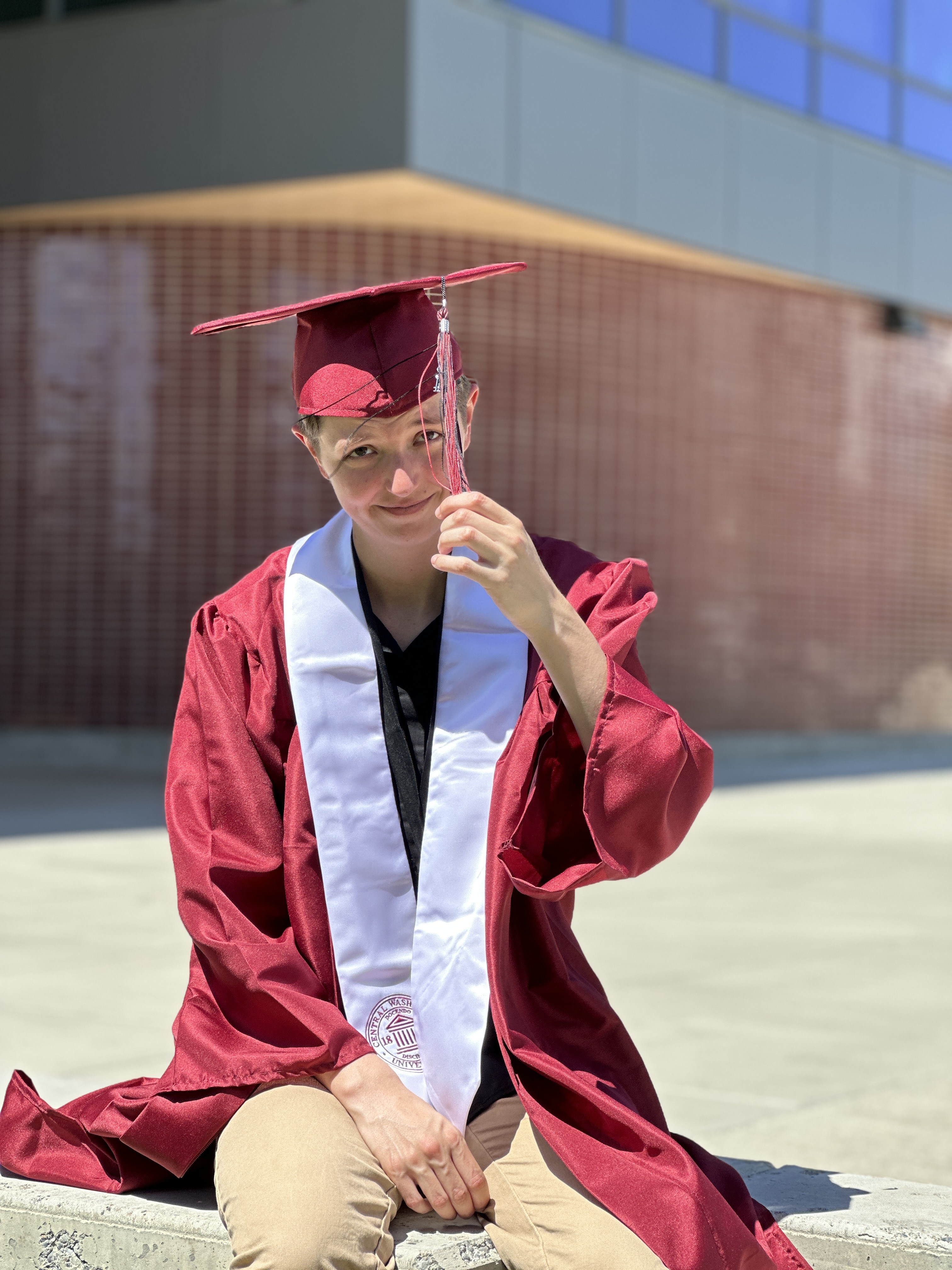 Hollis Zepp posing in red graduation gown and cap