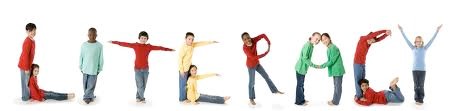 Children in brightly colored clothing spelling out "Literacy" by posing.