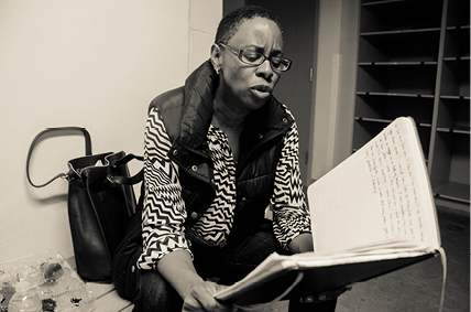 A black and white picture of Dr. Lisa Thompson reading a book.