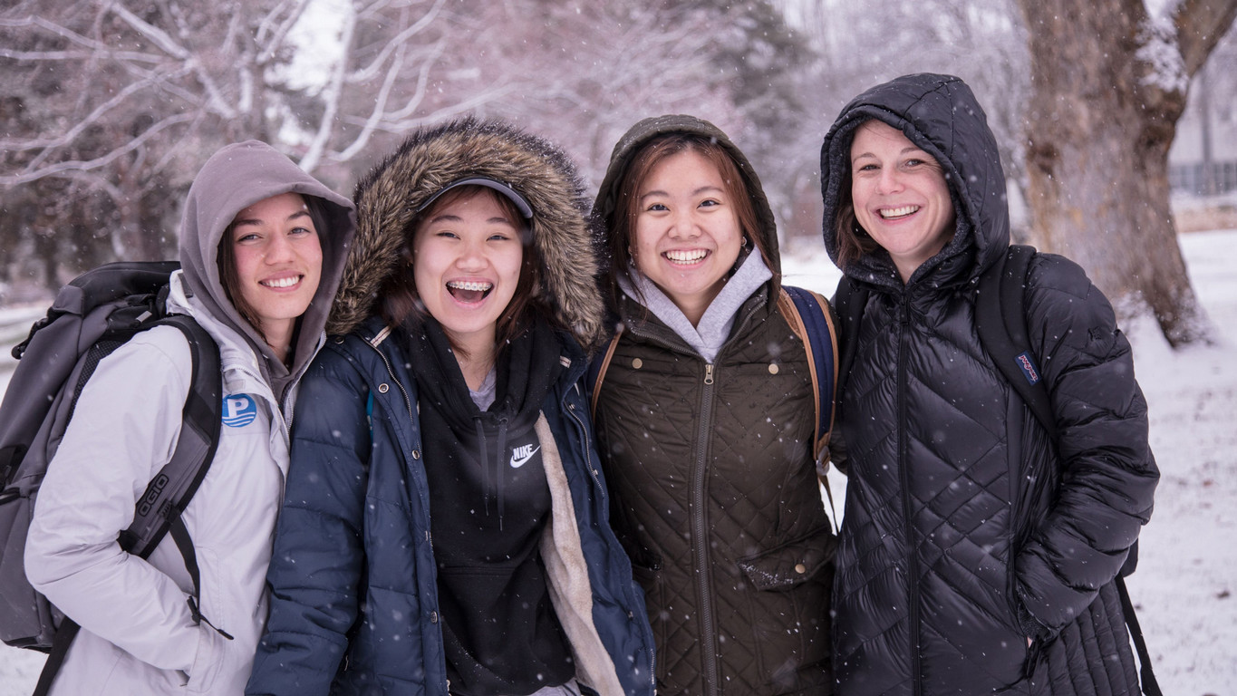 A captivating photo of four women smiling in the snow who partake in the ESL program at Central Washington University.