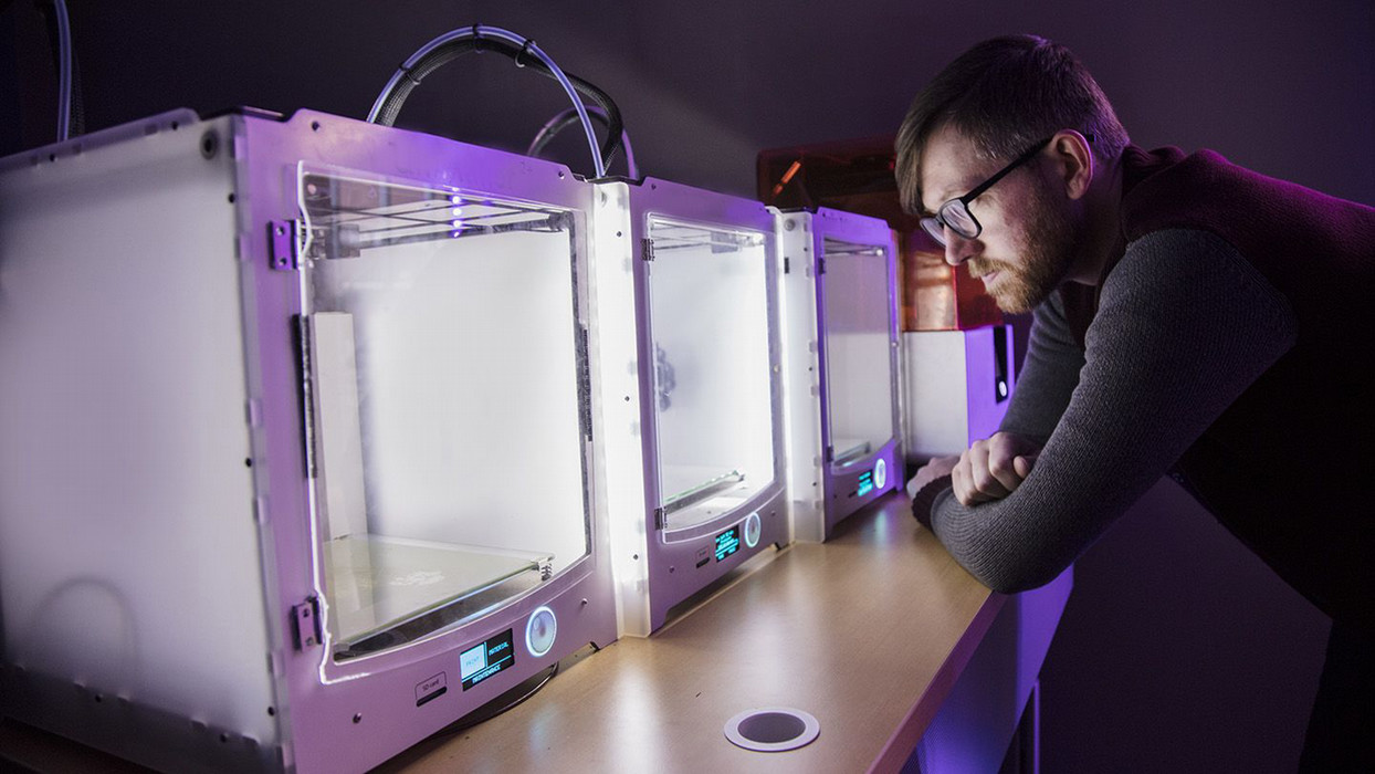 A man takes a close look at the 3D printers within the multimodal education center at Central Washington University.
