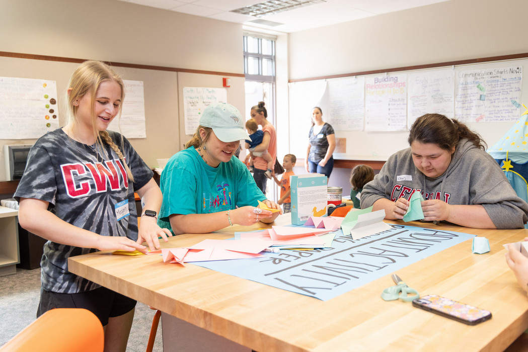 Three women within the teaching learning education program at Central Washington University partake in arts and crafts.