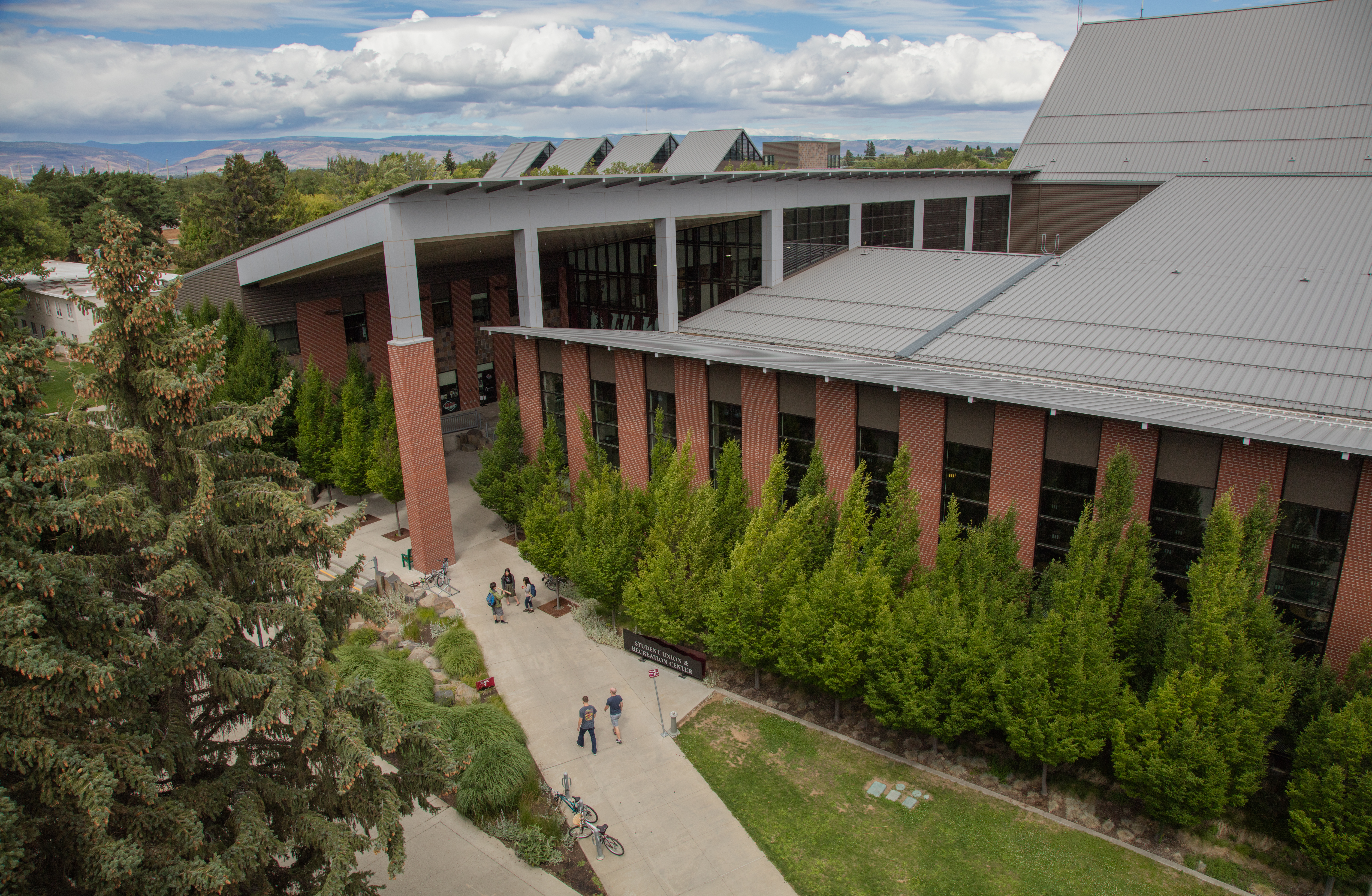 Aerial camera shot of the SURC and students walking to and from the building