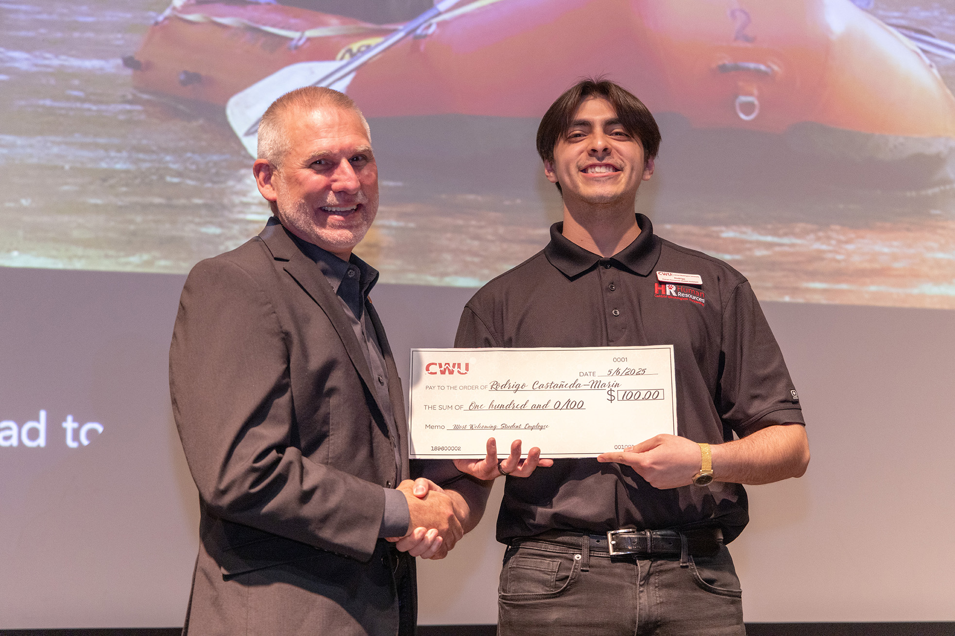 Student Rodrigo Castaneda-Marin accepts his award check from President Wohlpart