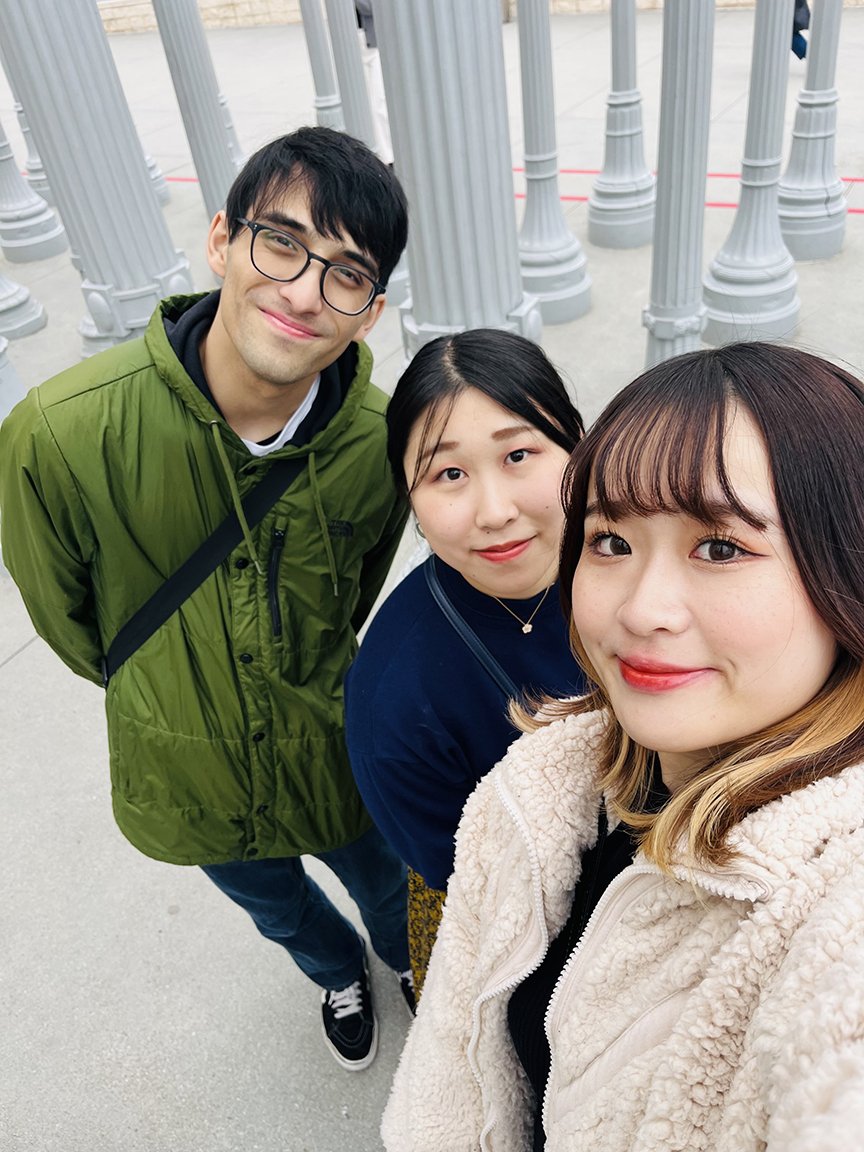 AJ Ingberman with two Japanese women in front of pillars
