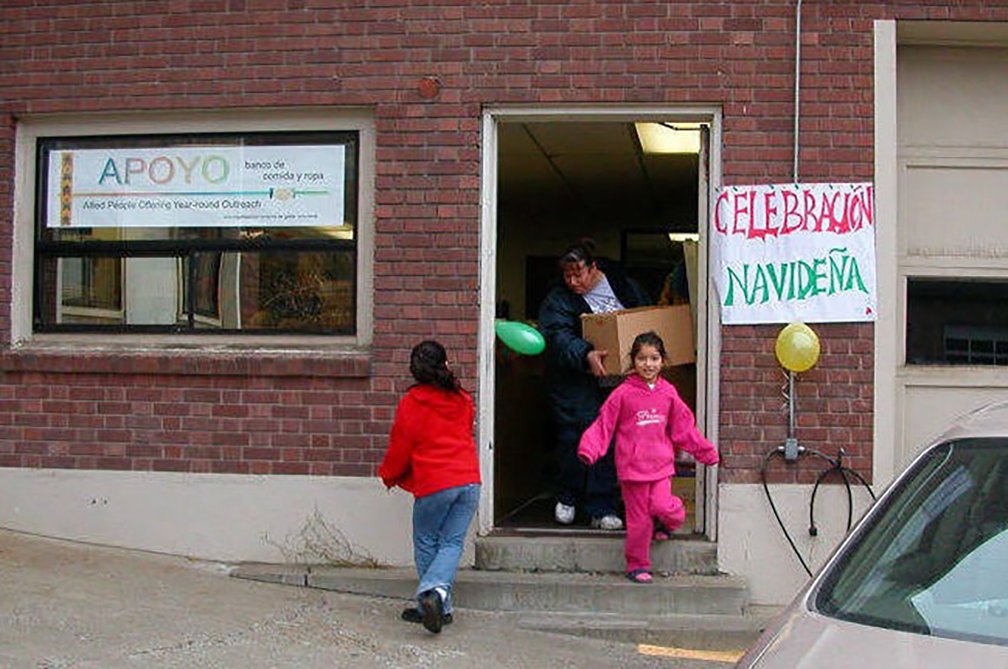 A family picks up a donation at the former APOYO facility on University Way.