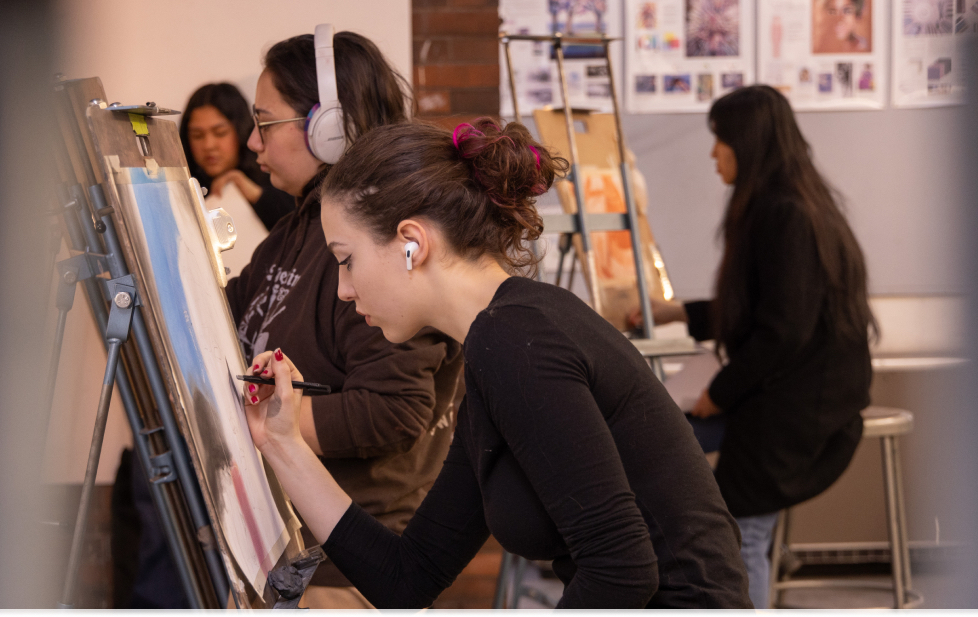 An art student paints on a canvas