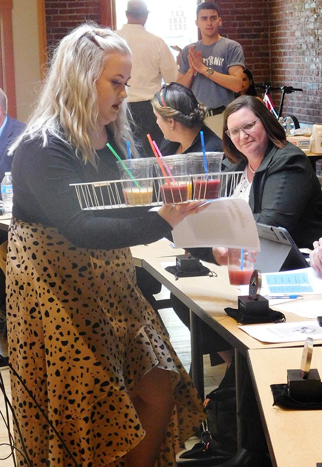 A Cat Tank contestant shares her product with the judges