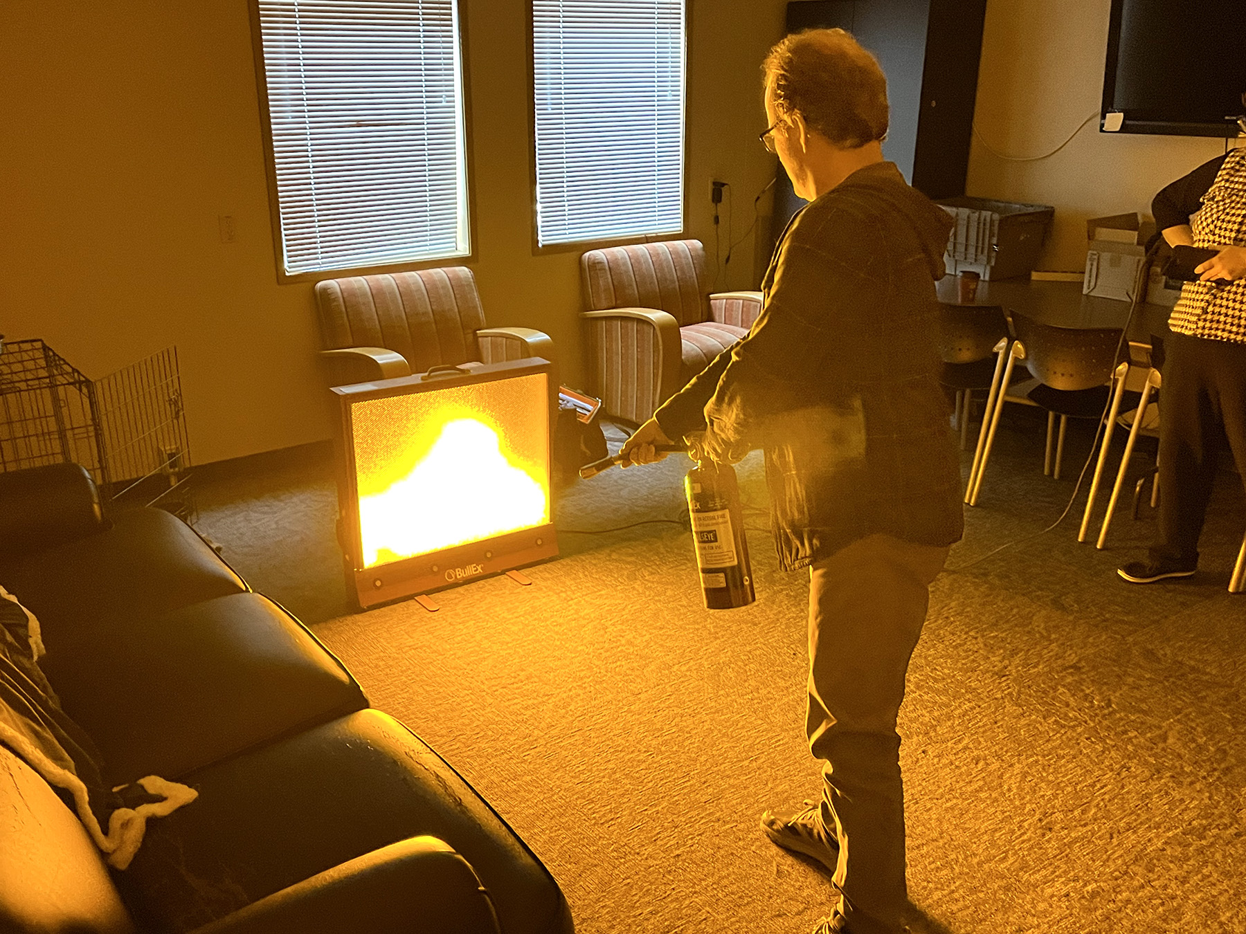 CERT training participant uses a fire extinguisher to put out a fire