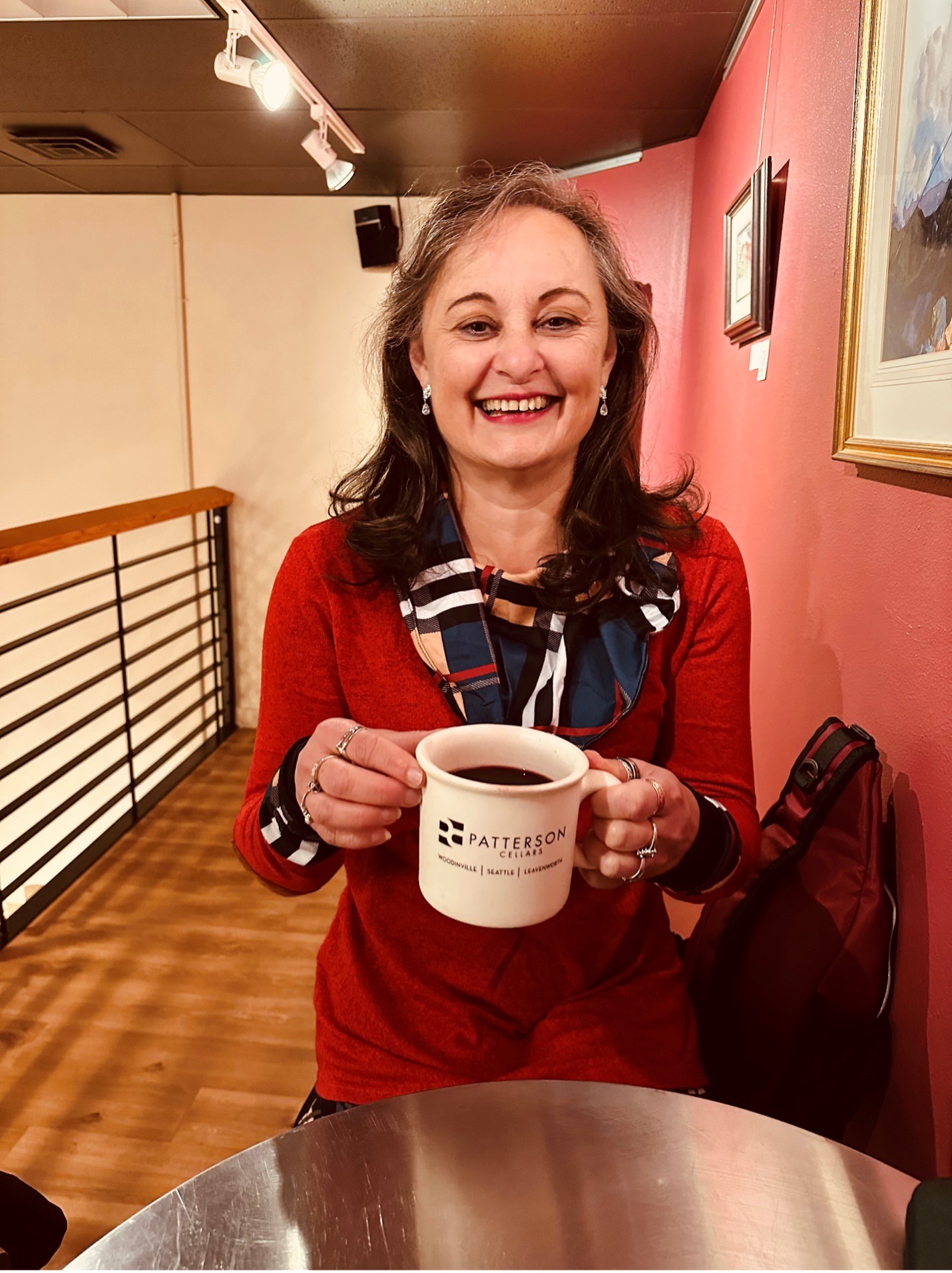Conchita Chinchilla smiles, holding a coffee mug