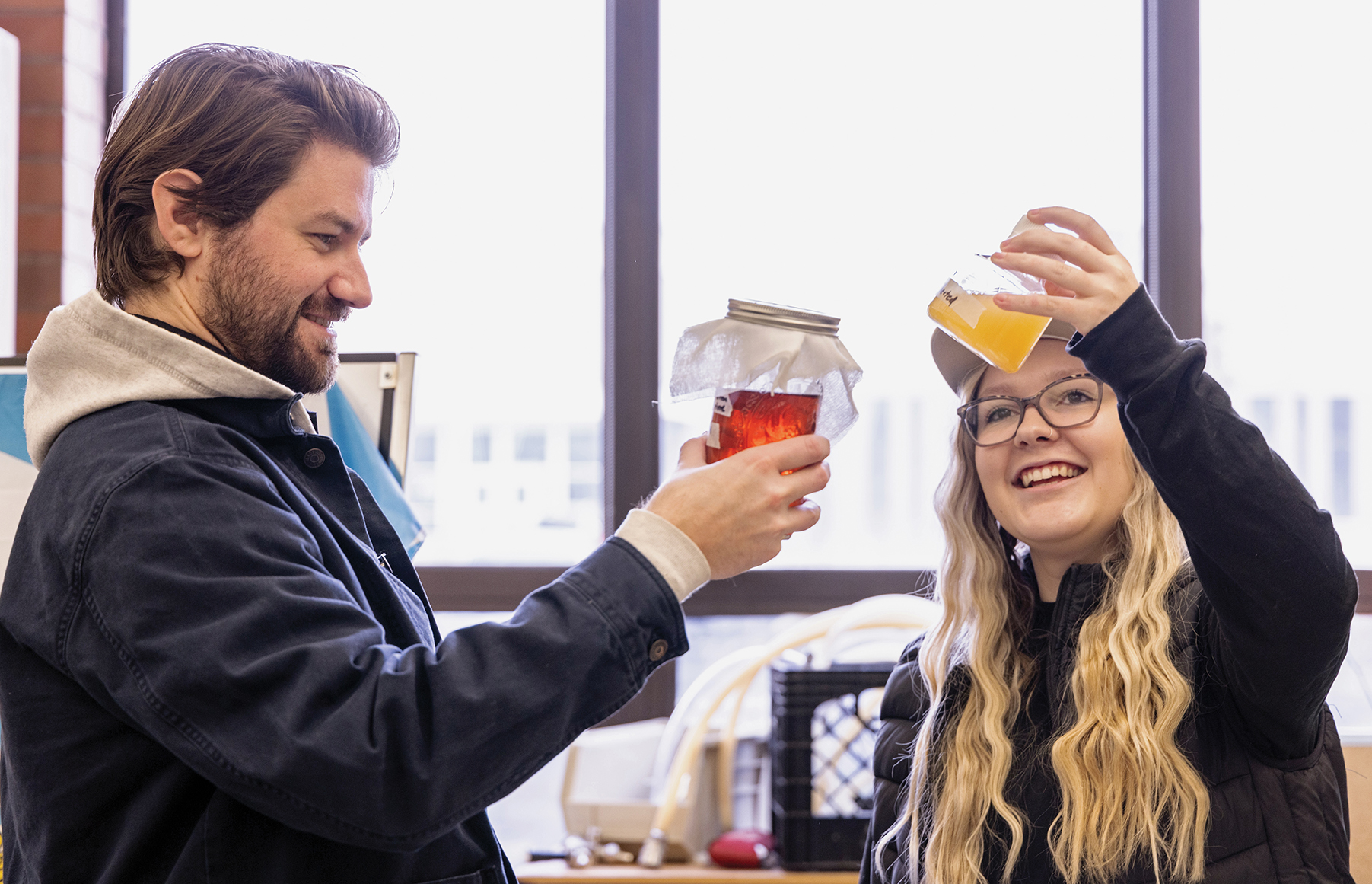 Students hold up a glass of beer for inspection