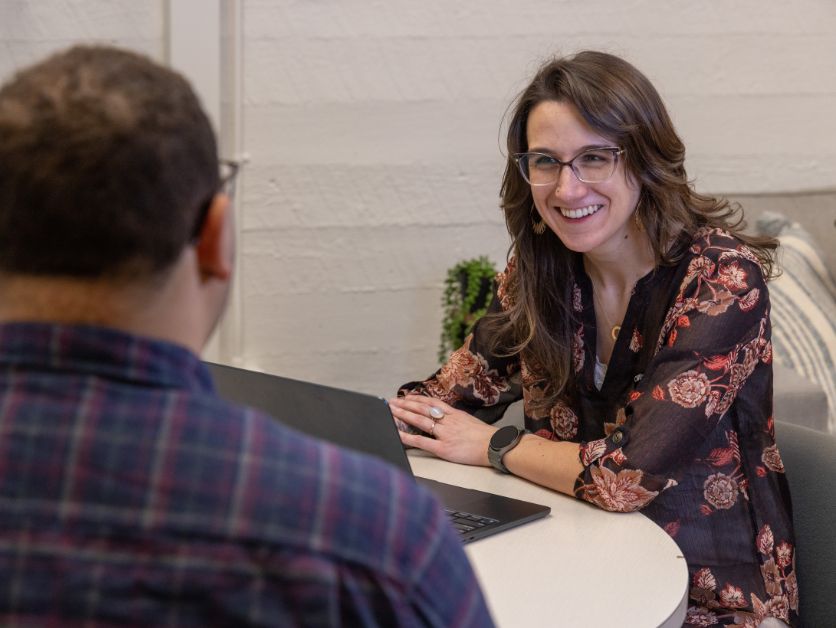 Kelly Boozer sits with a client at the Basic Needs office