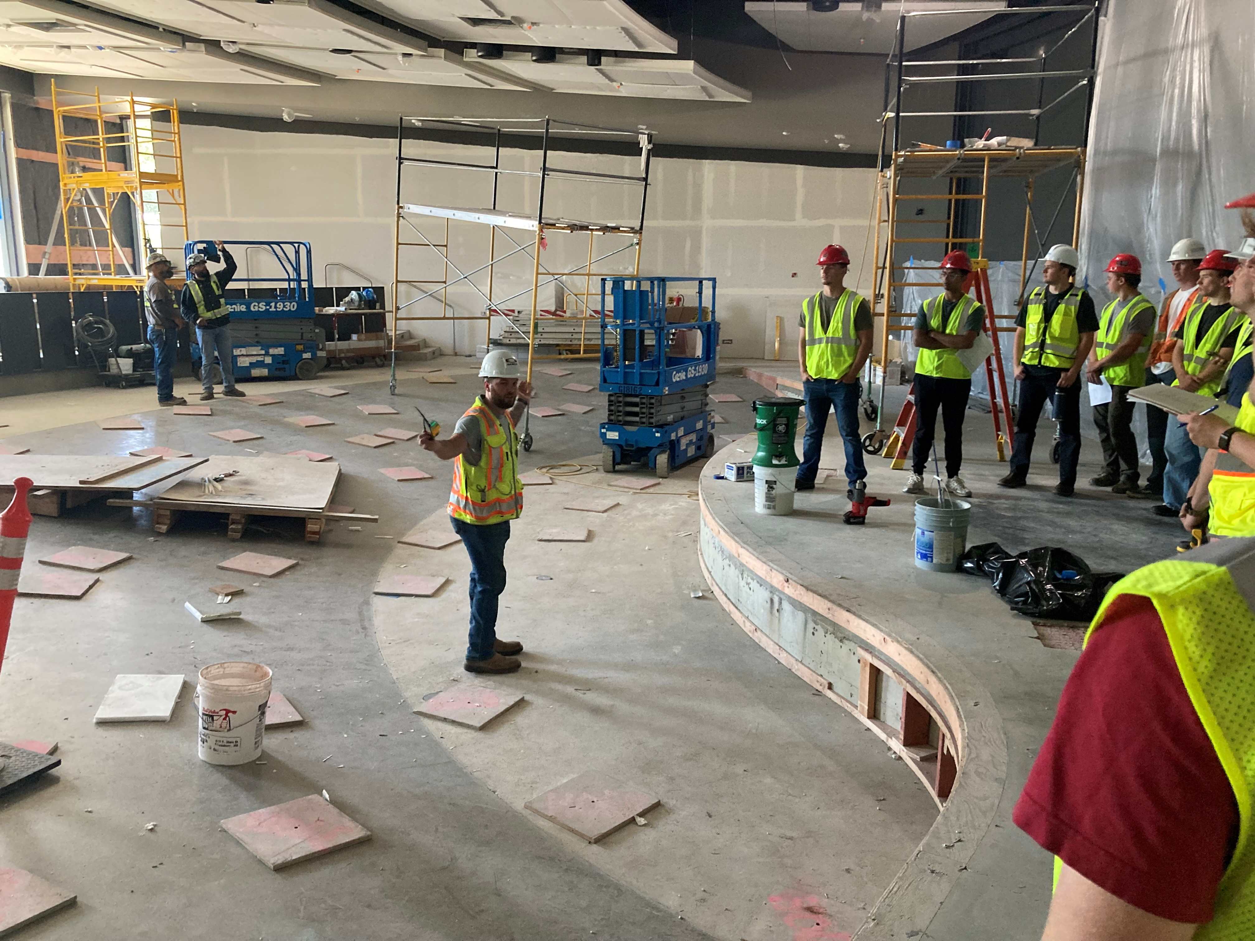 Students in hard hats explore the NAC construction site.