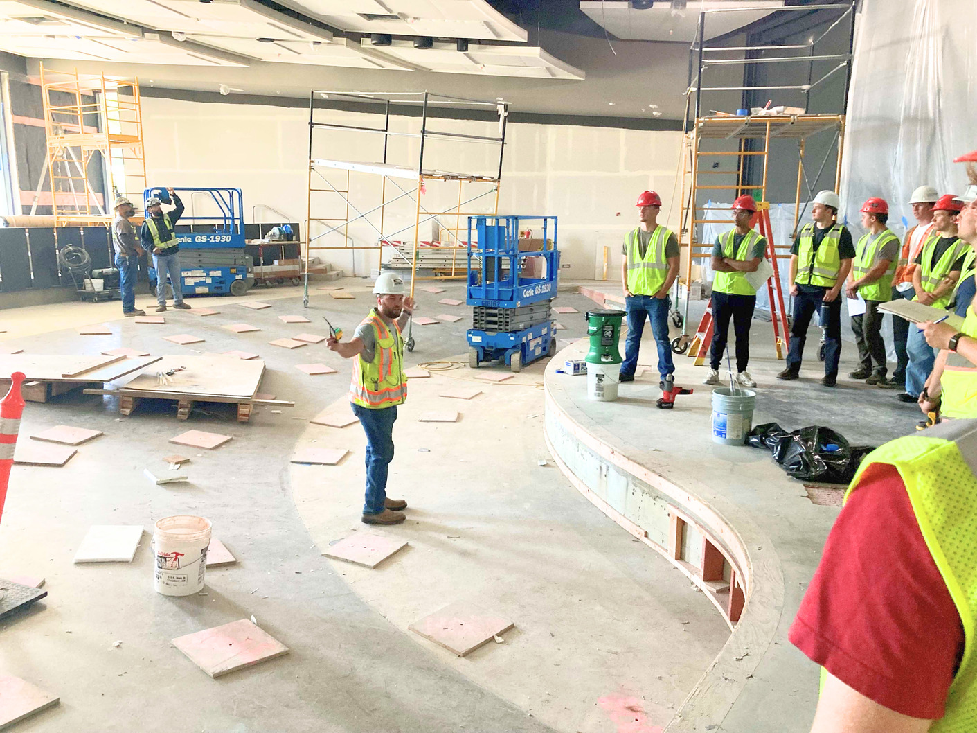 Students in hard hats explore the NAC construction site.