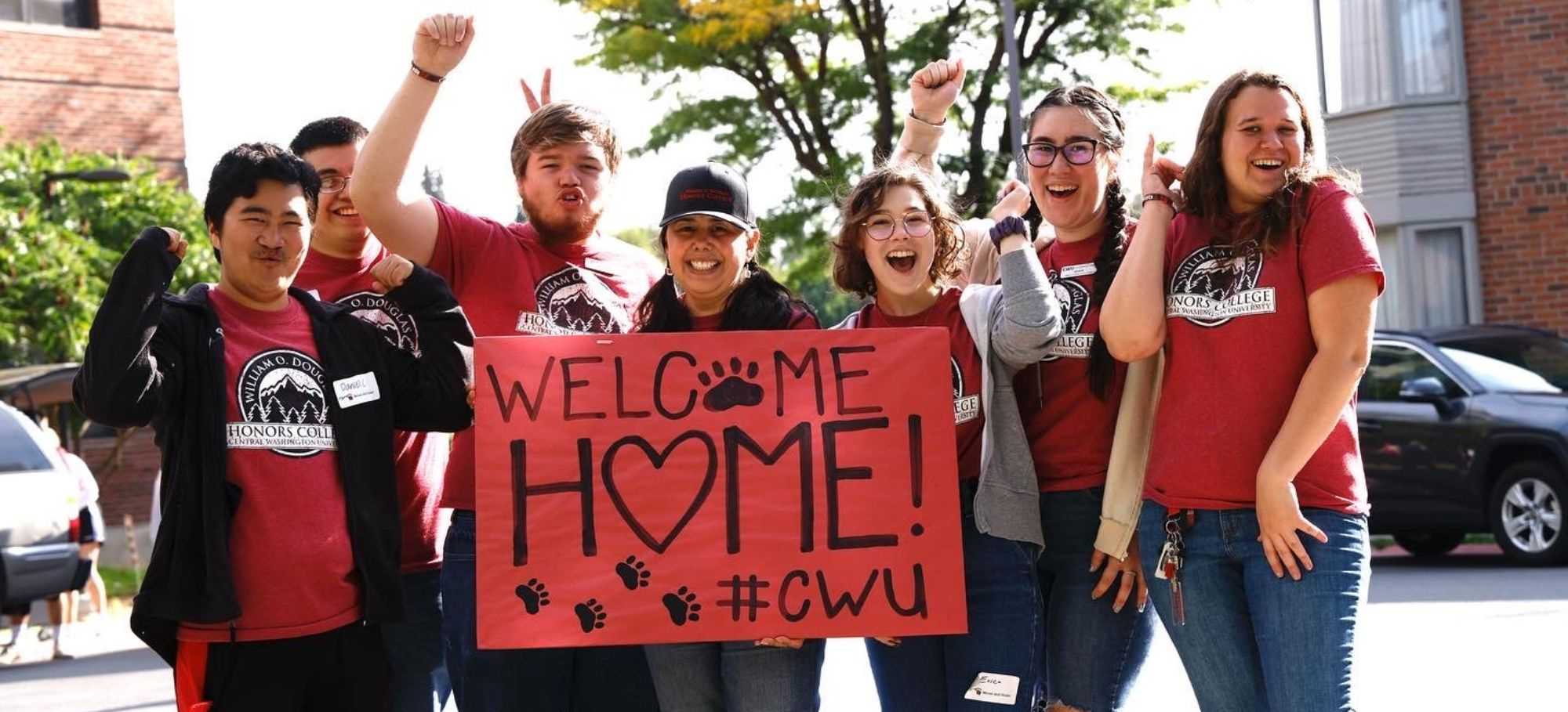 DHC students hold up a banner welcoming freshmen to campus