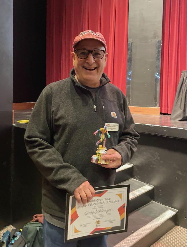 Photo of Gregg Schlanger holding his hand-painted award.