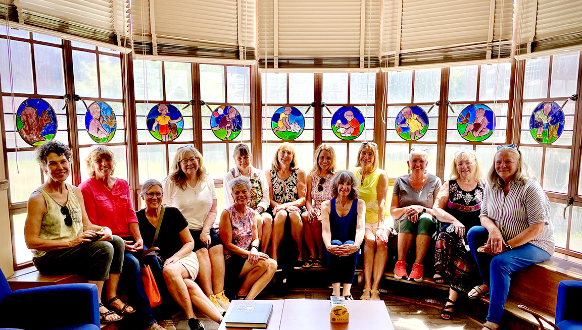 The Reunion gorup poses with a stained-glass window they remember from their childhood.