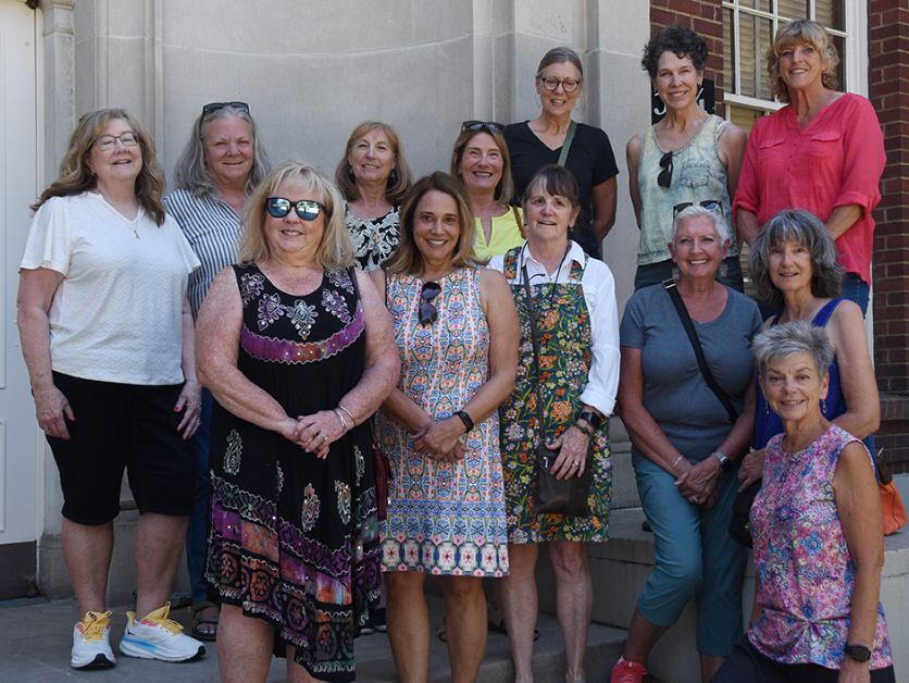 The Hebeler Elementary School Reunion group poses in front of the building that used to be their elementary school.