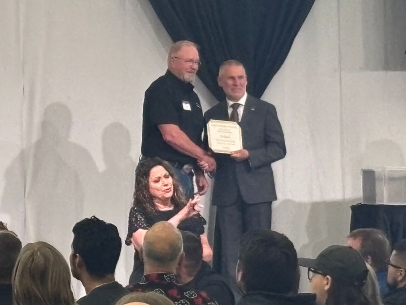 Joe Bach receives an award from President Jim Wohlpart