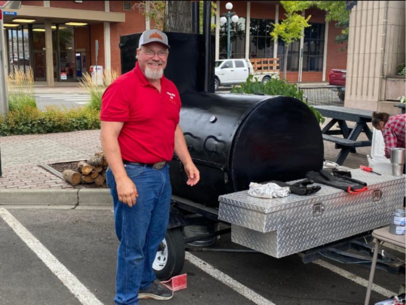 Joe Bach and his smoker, wearing a Taneum Creek BBQ hat.