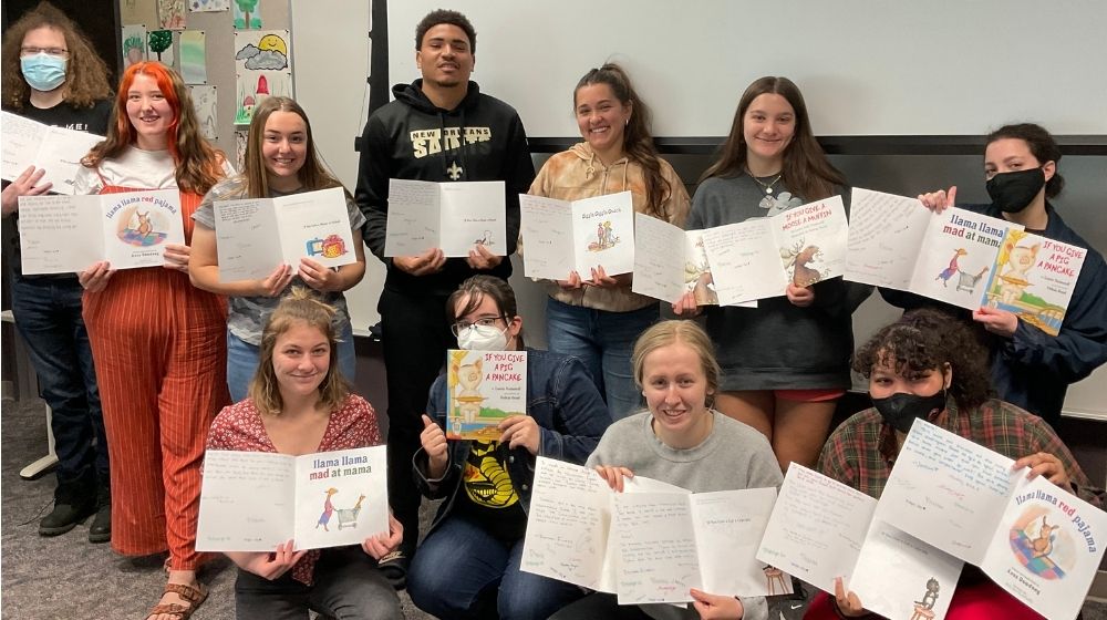 Students from CWU's Culturally Responsive Teaching course display uplifting messages they wrote in children's books. The books will be donated to the children from Robb Elementary School.