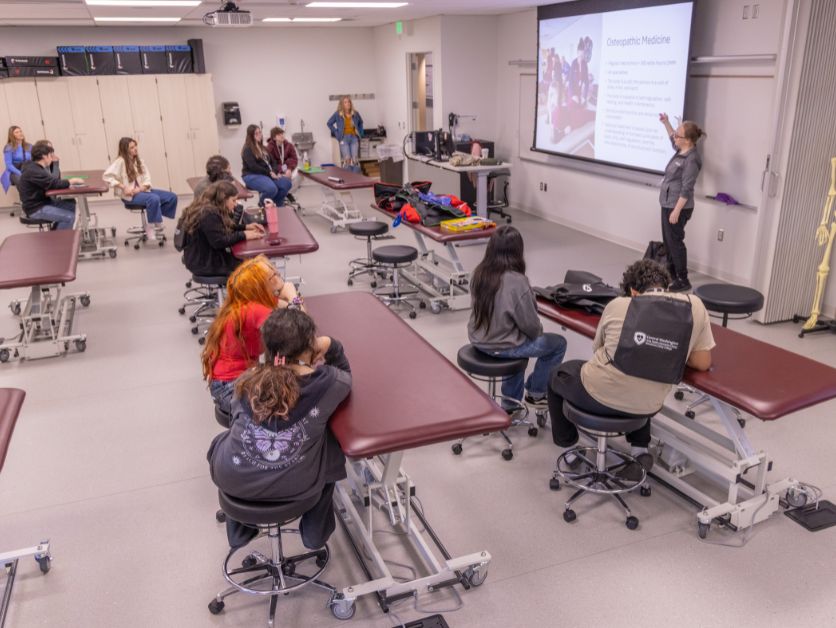 Students gathered in a classroom learn about a health science discipline from a pro.
