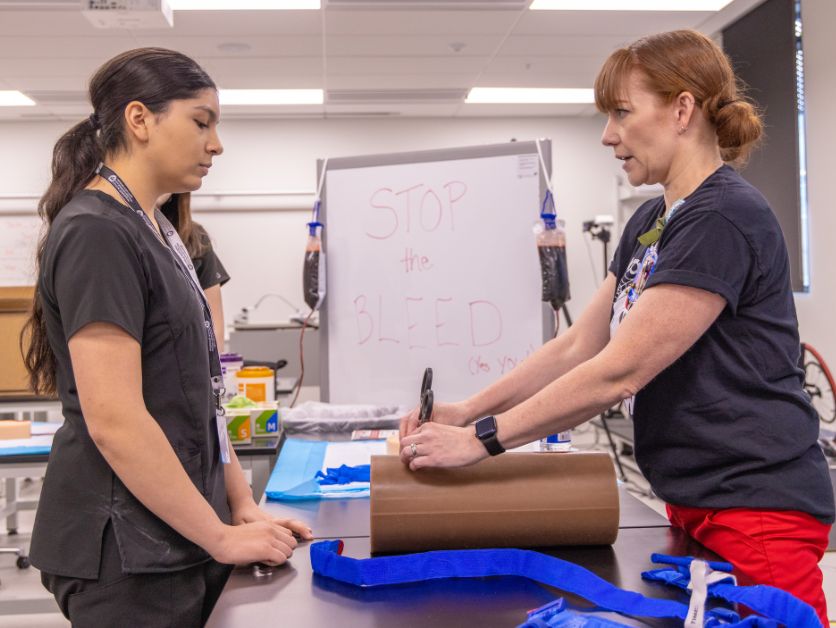 A high school student and a medical professional discuss how to stop bleeding effectively.
