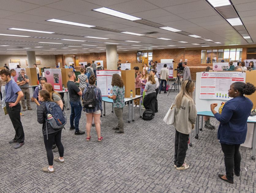 A crowded poster presentation session in Brooks Library, as part of SOURCE.