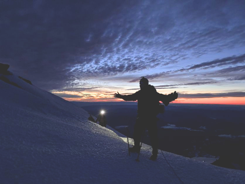 Sunrise behind a climber on Mount Rainier