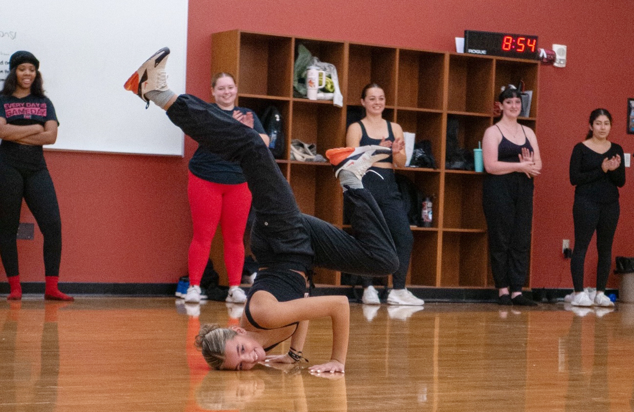 A CWU dance team member performs a trick
