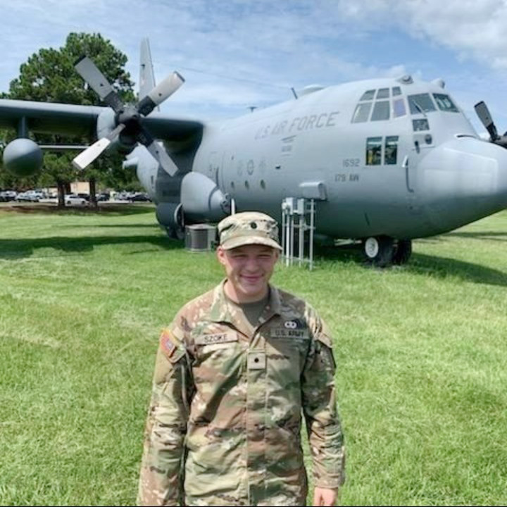 Elliott Szoke in front of a military airplane