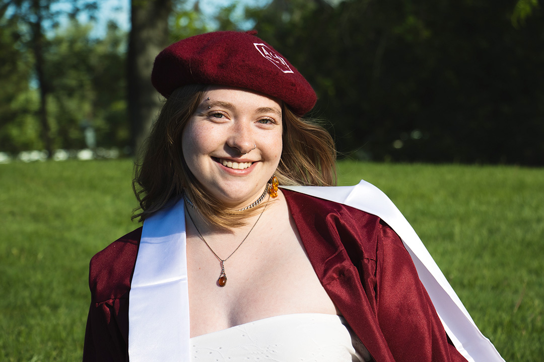 Alex Littman poses in her graduation regalia