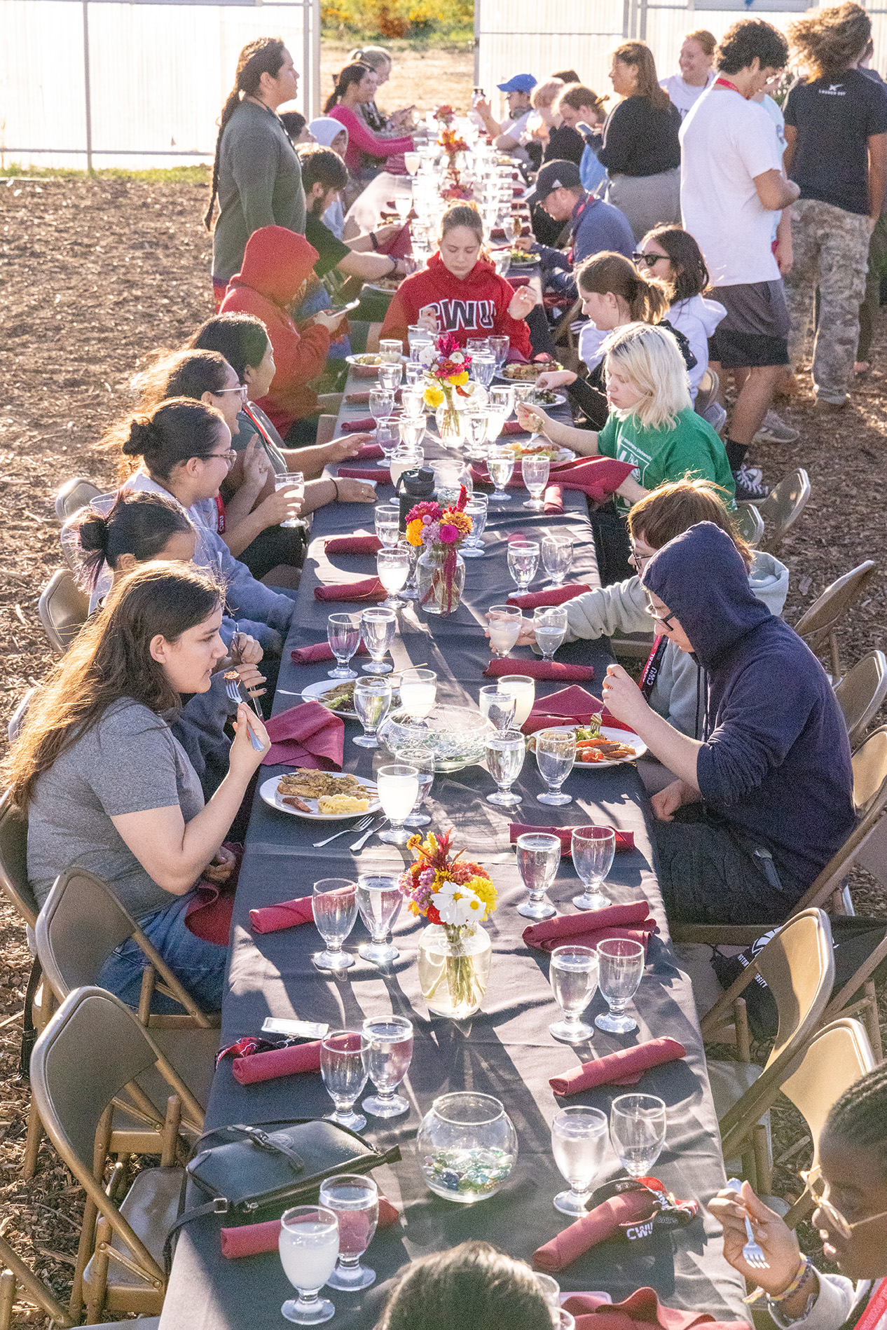 Students eat dinner at a long table at The Farm