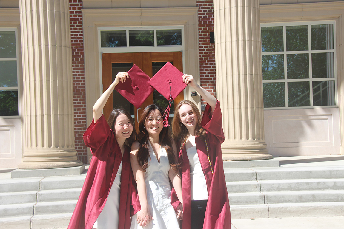 Kaelan Kavanaugh, right, celebrates with two fellow graduates outside Shaw Smyser Hall