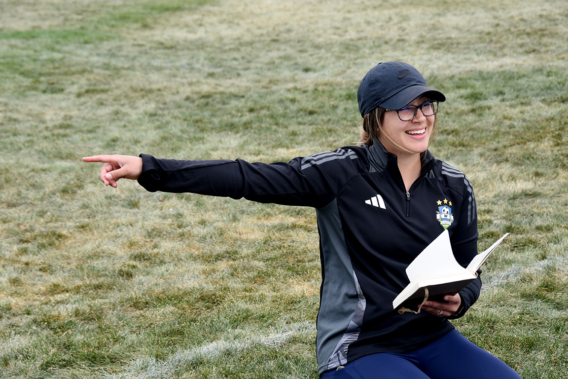 Kayla Gout points to the field as she coaches her youth soccer team.