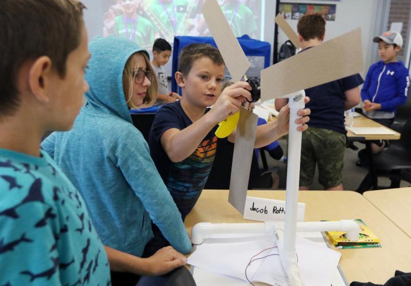 Boy attaches blades to a wind turbine during the KidWind Project workshop at CWU
