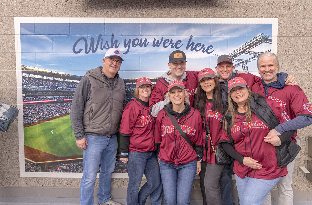 A group of CWU alumni take a photo at T-Mobile Park.