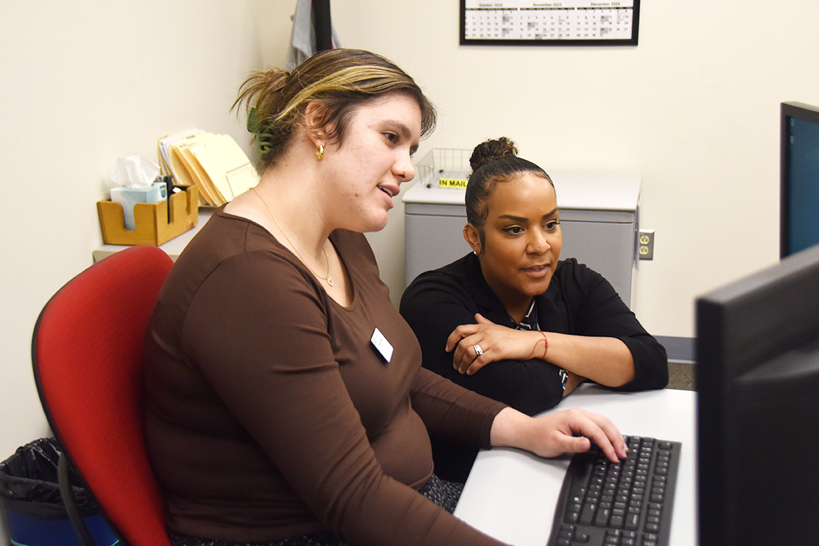 Gonzales engages with Office Administrator Hannah Schneider in the Dining Services office.