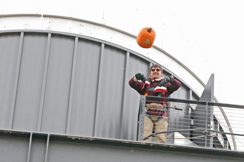 CWU student Martin Mattes tosses a pumpkin off the roof of the Discovery Hall and Planetarium