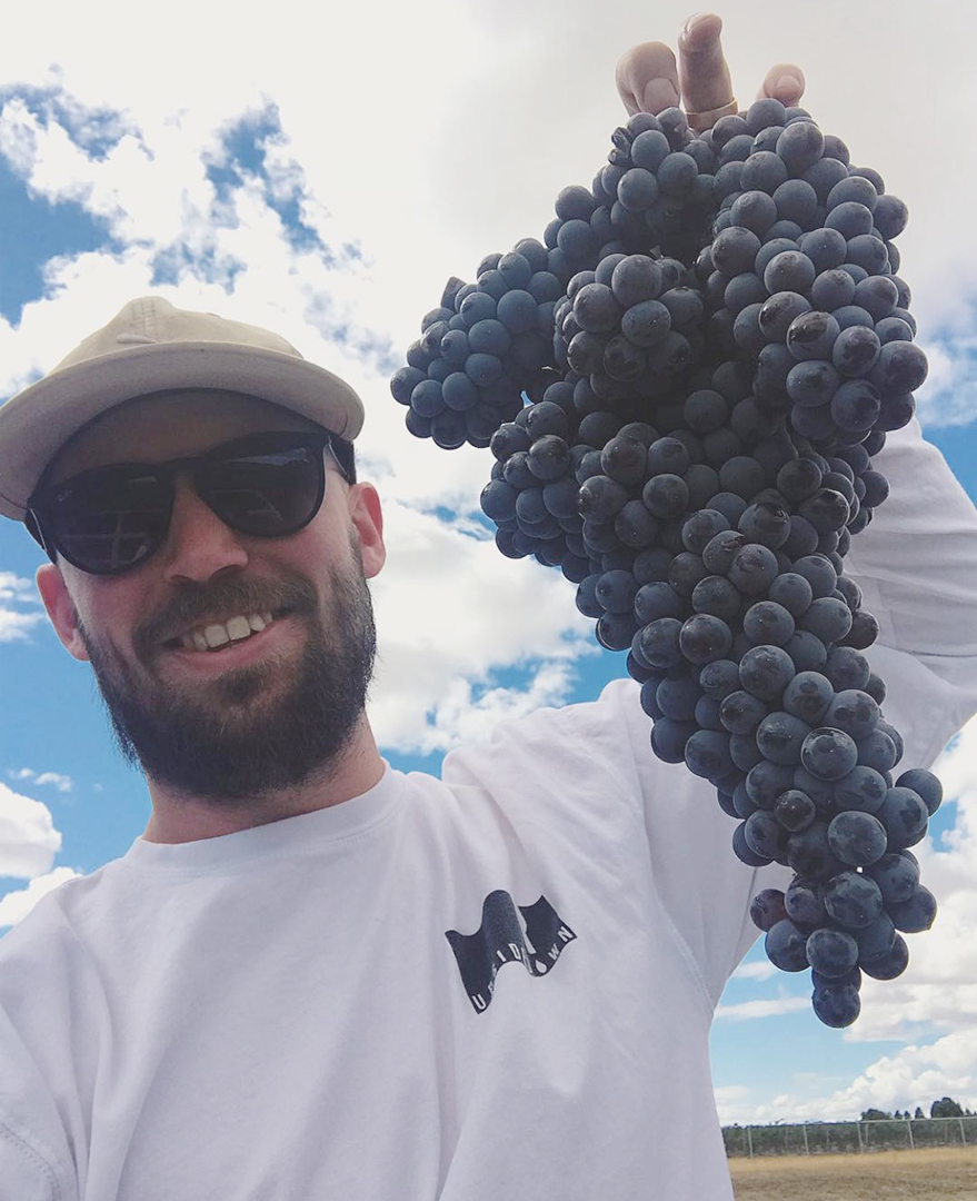 Seth Kitzke holds up grapes