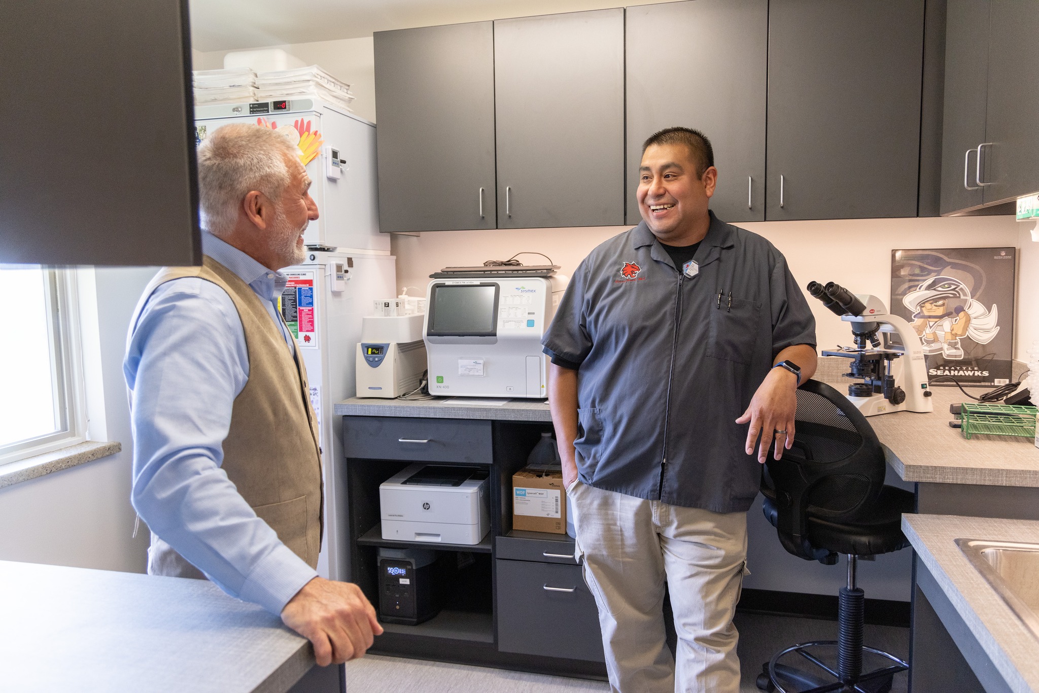 Lab tech Danny Nambo talks to President Jim Wohlpart in the new SHS lab.