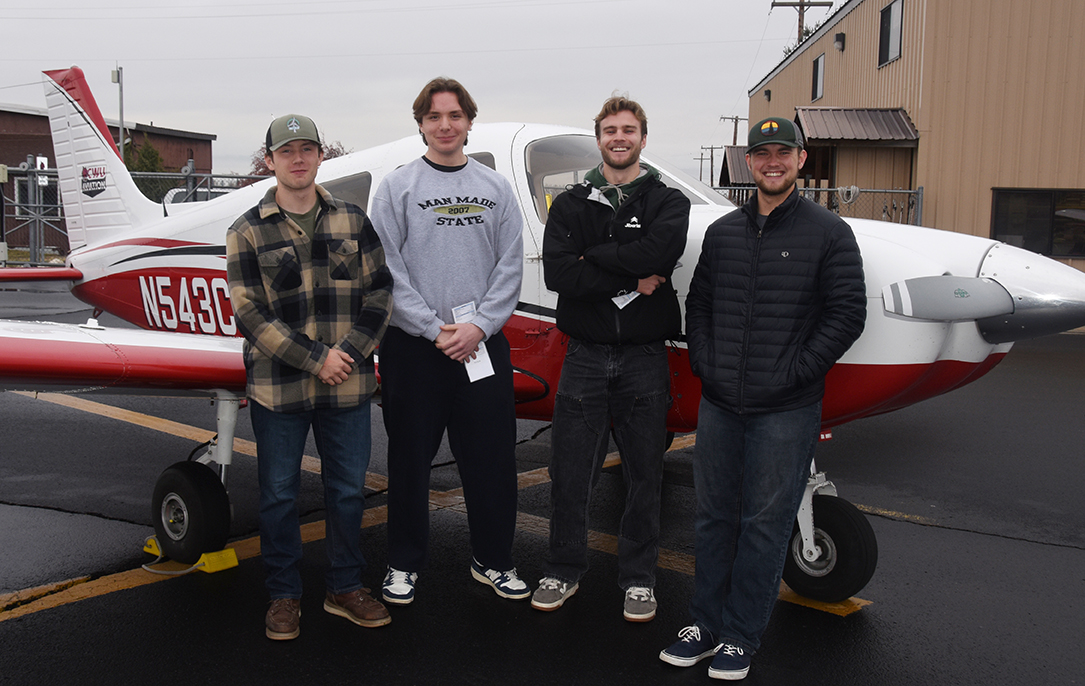 First-year aviation students pose in front of a plane at Bowers Field