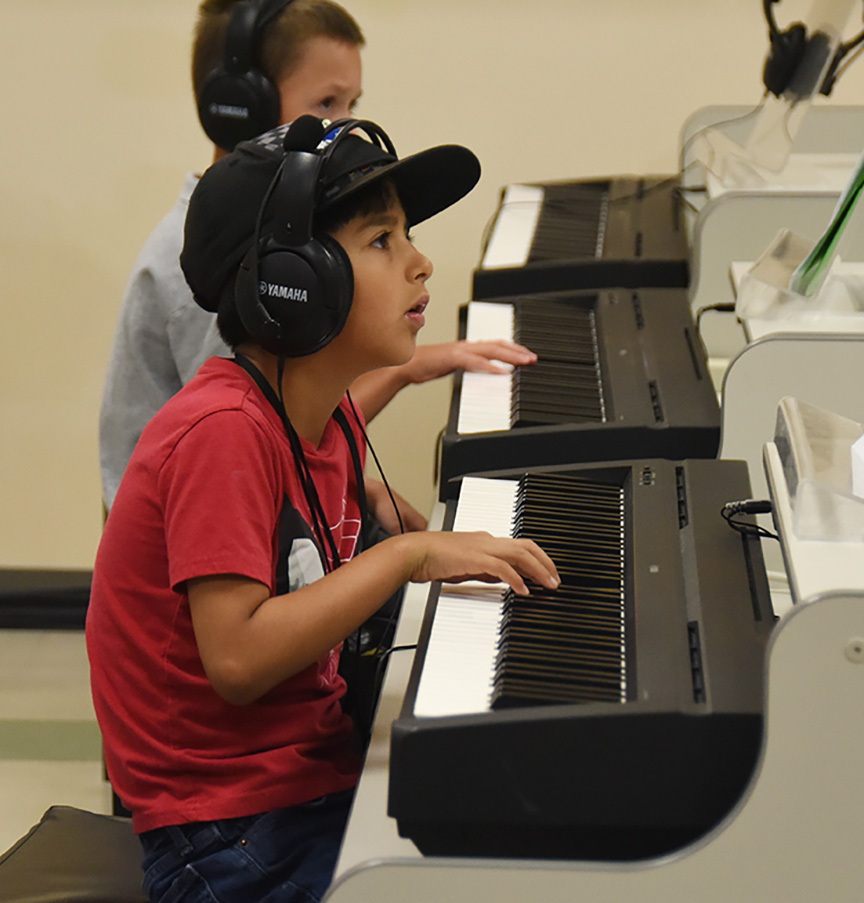 A SLYM camper practices his piano skills