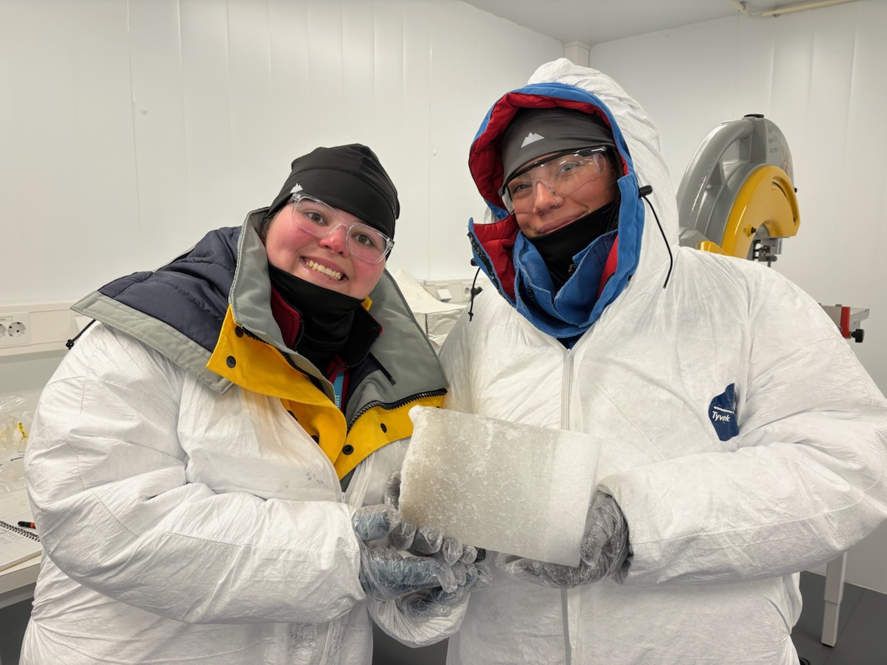 CWU grad students hold up an ice core sample inside a lab in Norway