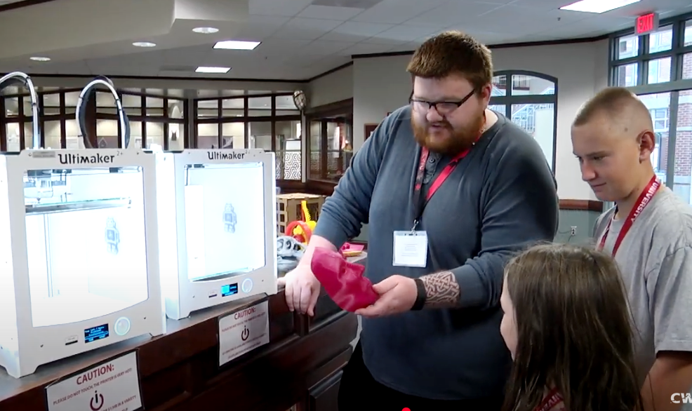 A Teach STEM instructor shows elementary students around the science lab.
