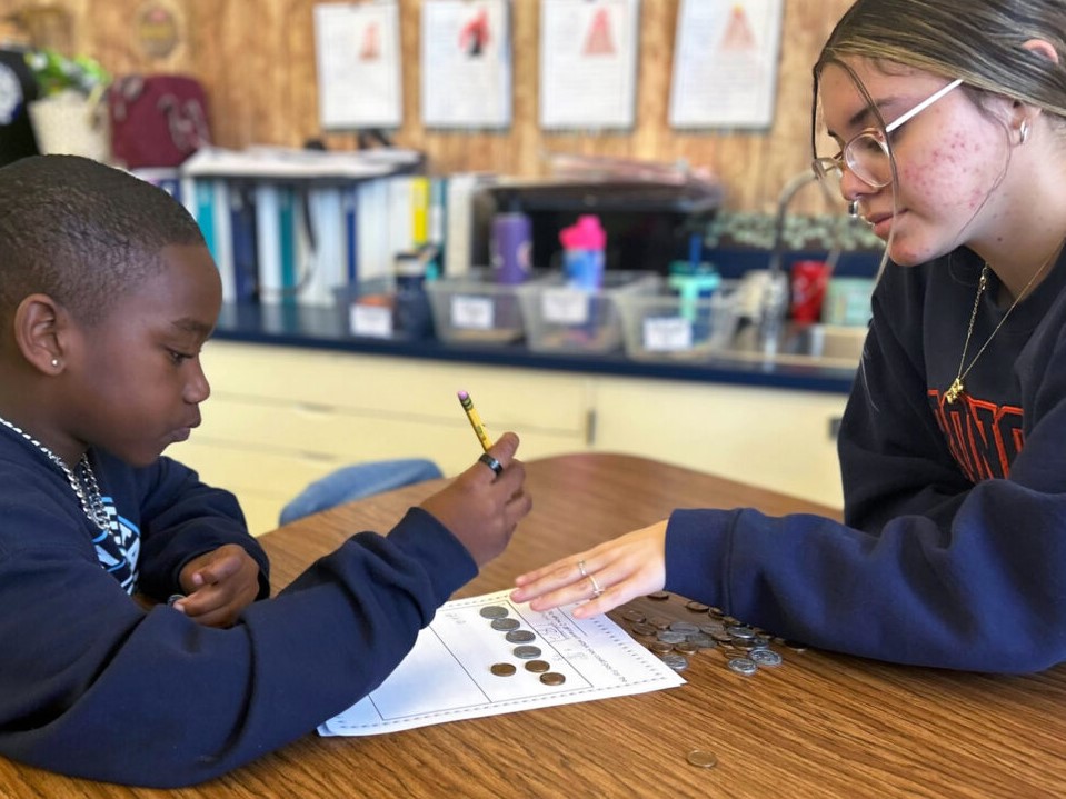 An aspiring teacher works with a student