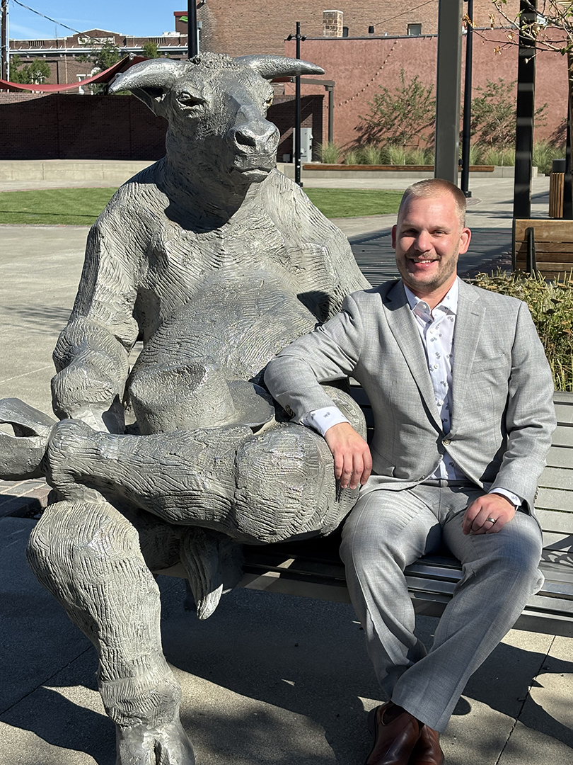 Tony Swartz sits next to the bull statue in downtown Ellensburg